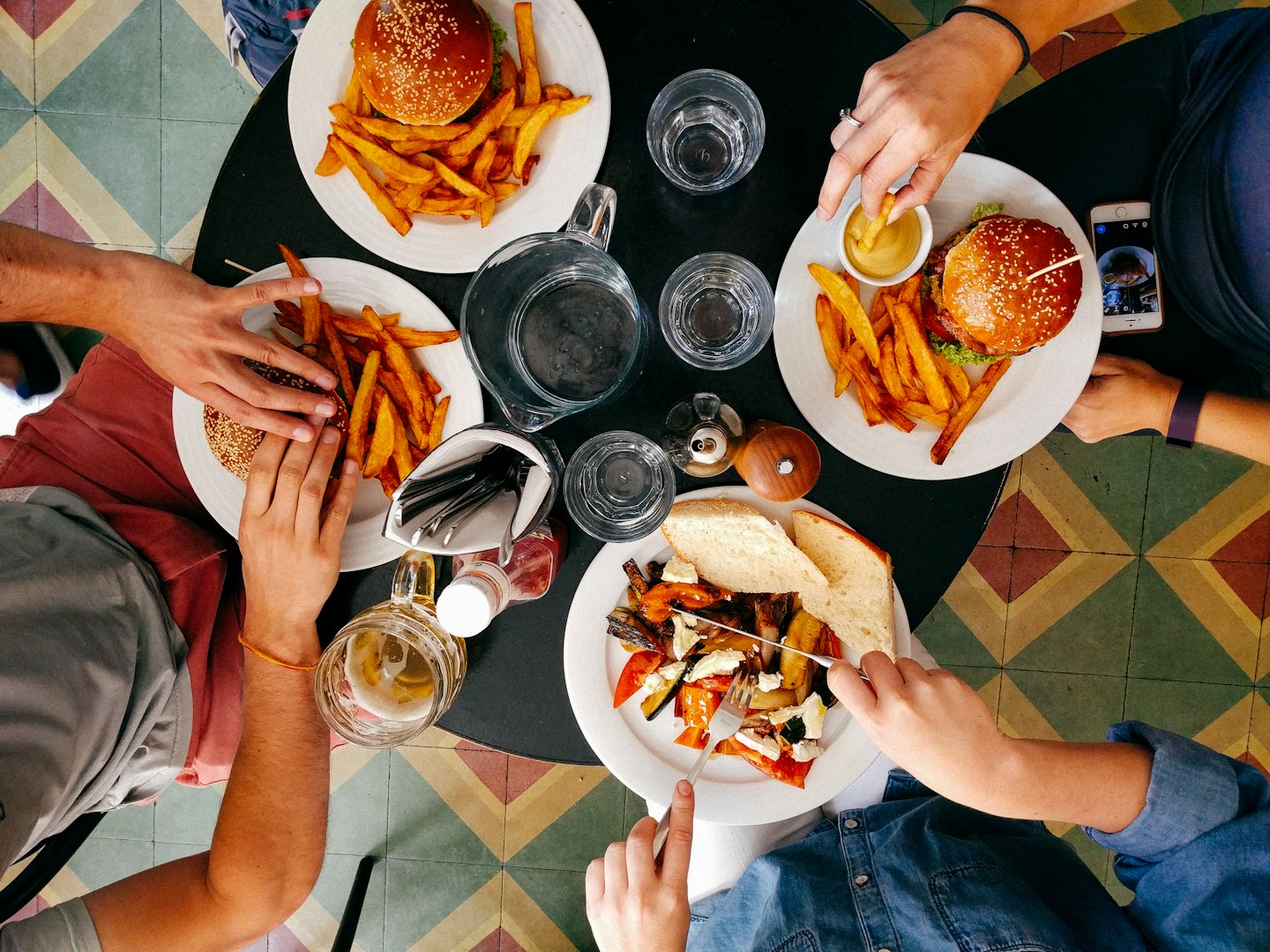 Four people share a casual meal around a circular table.